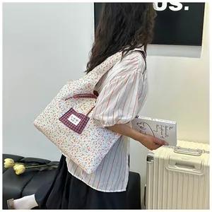 Detail of quilted floral tote bag showing side contrast plaid pocket and cotton texture