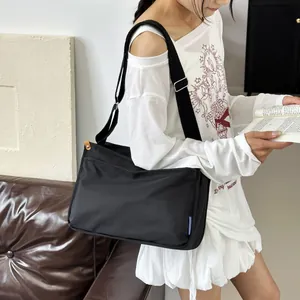 Minimalist black messenger bag with adjustable strap and large capacity in a lifestyle setting