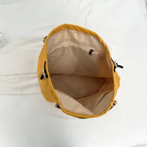Yellow casual bucket bag interior with zipper pocket and colorful striped strap