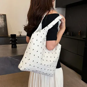Minimalist white tote bag with black bow print worn by a model for a chic daily look
