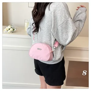Pink shell-shaped oxford fabric crossbody bag shown on a model for daily style
