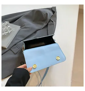 Detail van de lichtblauwe crossbodytas met dubbele magneetsluitingen en zwarte voering