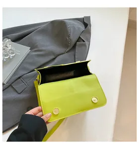 Detail van de opening van de neongroene tas met dubbele gouden magneetsluitingen