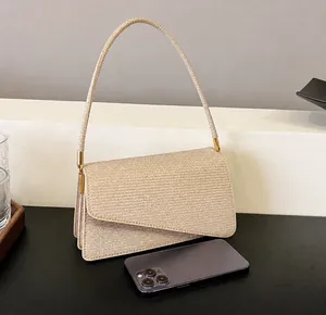 Close-up of golden glittery shoulder bag with flap closure and unique strap details