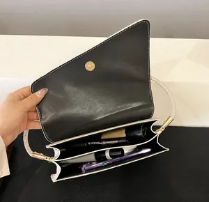 Detail of the asymmetric flap shoulder bag showing internal dual compartment storage space