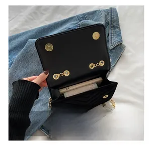 Detail showing the internal storage capacity and gold snap button of the quilted chain bag