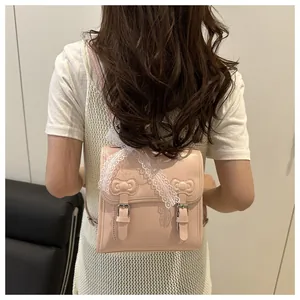 Close-up of pink lace backpack with bow detailing on a model's back in soft light