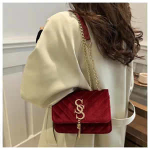 Deep red velvet crossbody bag with V-shaped quilting and golden tassel detail