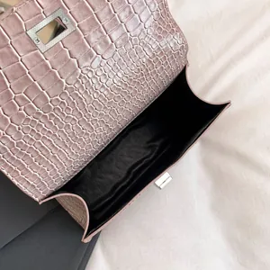Pink faux crocodile leather crossbody bag with silver twist lock and black interior