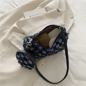 Blue and white plaid crescent bag with frayed edges and matching coin purse on suit