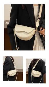 Détail du sac selle demi-lune blanc crème avec rabat ondulé et large bandoulière