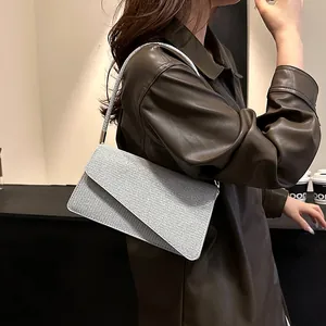Silver sequin shoulder bag with asymmetric flap shown on model with leather jacket