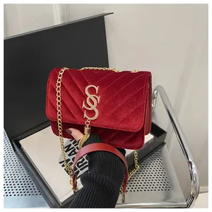 Close-up of burgundy velvet chain bag with V-quilted stitching and golden tassel detail