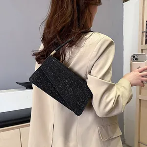 Chic black sequin underarm bag with shimmering finish and sleek rectangular flap design