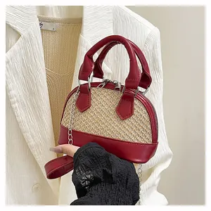 Detailed macro view of burgundy leather and beige woven straw texture on shell handbag