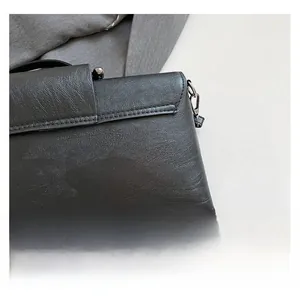 Close-up of black litchi grain leather clutch with vintage silver ball clasp closure