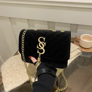 Elegant black velvet chain handbag with V-shaped quilting and gold metal tassel logo