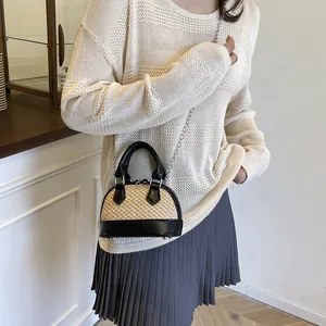 Minimalist straw woven shell bag with black leather trim and chain strap for summer