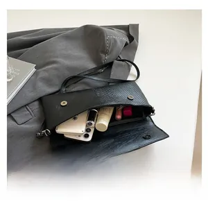 Interior capacity of snakeskin pattern envelope bag showing phone and cosmetics