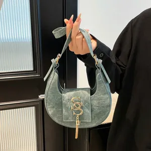 Borsa a mezzaluna retrò azzurra con logo SS dorato e frange metalliche alla moda