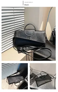 Detail of black faux leather handbag featuring snake skin texture and metal handle