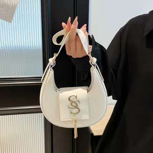 Borsa a mezzaluna bianca minimalista con ciondolo a frange dorate e logo in metallo