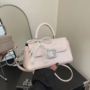 Sac à main en cuir PU rose avec nœud en perles et dentelle, présenté de manière élégante