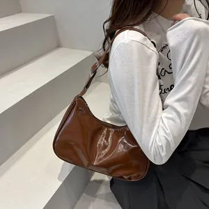 Borsa sottobraccio a mezzaluna in pelle verniciata lucida marrone con fibbie argento