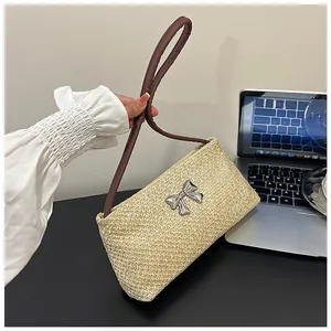 Détail du sac tressé avec boucle de nœud argentée et poignée en cuir marron