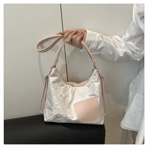 Close-up of silver jacquard pattern and pink leather pocket detail on shoulder bag