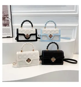 Detail of elegant handbags with woven handles, flower locks and textured fabric finish