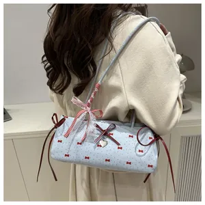 Detail of blue bow-patterned shoulder bag with lace trims and red checkered ribbon accents