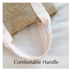 Detail shot of the comfortable off-white canvas handles on the woven straw tote bag