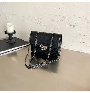 Détail de la boucle boucle argentée et motif matelassé sur sac bandoulière noir