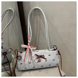 Detail of light blue shoulder bag with red floral print and stylish checkered ribbon bow