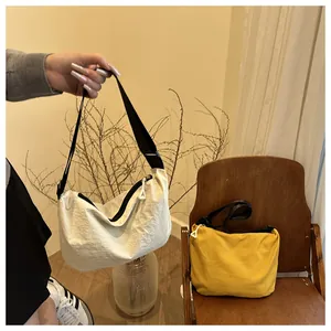 Detailed view of cream and yellow crescent nylon bags with adjustable wide shoulder straps