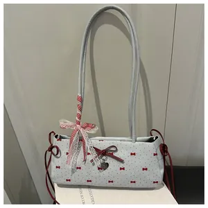 Detail of light blue shoulder bag with red bow pattern and lace ribbon handle
