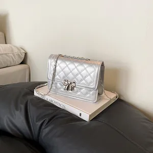Sac à bandoulière argenté matelassé avec fermoir nœud métallique et chaîne chic
