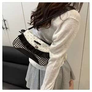 Detail view of the black and white bow shoulder bag with heart pattern and ribbon