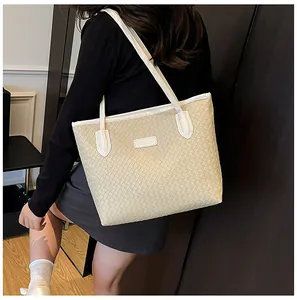 Detail of beige woven tote bag with white shoulder straps and Fashion & Bags label