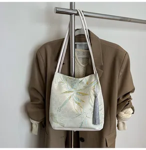 Detail of bamboo jacquard pattern and tassel charm on a beige Chinese style tote bag