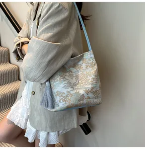 Detailed view of Oriental mountain print on tote bag with a grey silk tassel charm