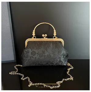 Detailed macro view of the vintage black silk embroidery and golden hollow metal handle