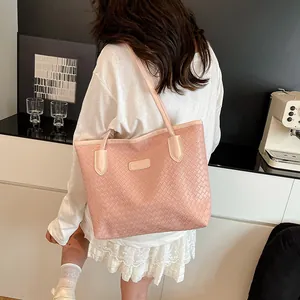 Pink woven tote bag for women with dual straps shown in a stylish lifestyle setting