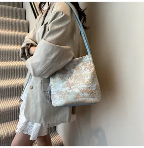 Detail of light blue jacquard shoulder bag with tassel and oriental tree pattern