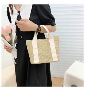 Detailed straw woven texture and durable ribbon handle of a minimalist summer beach tote bag
