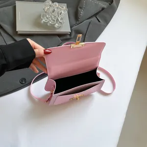 Sac bandoulière minimaliste en cuir rose avec fermoir doré et espace de rangement