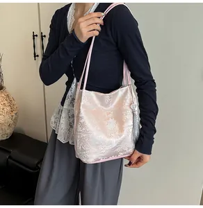 Detail of pink jacquard shoulder bag with Chinese embroidery and silver tassel charm