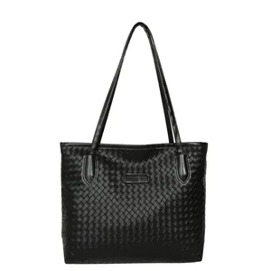Black woven leather tote bag with long shoulder straps and spacious minimalist design