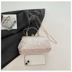 Detailed top view of a pink jacquard clutch bag next to a smartphone for scale